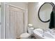 Cozy powder room with a decorative shower curtain, pedestal sink, and warm neutral tones at 801 Windsor Rdg, Canton, GA 30115