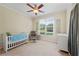 Neutral bedroom with a white crib, soft lighting, and a large window overlooking the neighborhood at 801 Windsor Rdg, Canton, GA 30115
