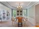 Elegant dining room featuring wainscoting, a modern chandelier, and natural light at 801 Windsor Rdg, Canton, GA 30115
