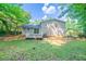 Back view of the home featuring a wooden deck and a spacious, tree-lined backyard at 1658 Pine Glen Cir, Decatur, GA 30035