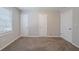 A bright bedroom featuring neutral walls, carpeted floors, and multiple doors and windows at 1658 Pine Glen Cir, Decatur, GA 30035