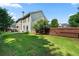 Backyard view of home with a spacious lawn, mature trees and privacy fence at 1691 Holcomb Lake Rd, Marietta, GA 30062