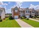 View of townhome with attached garage, landscaped yard, and inviting curb appeal at 176 Oak Green Dr, Lawrenceville, GA 30044