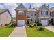 Charming two-story townhome featuring a brick facade, manicured lawn, and attached garage at 176 Oak Green Dr, Lawrenceville, GA 30044
