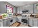 Bright kitchen with gray cabinets, stainless steel appliances, and natural light at 176 Oak Green Dr, Lawrenceville, GA 30044