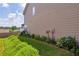 Landscaped side yard featuring flower beds along the tan siding of the home under a blue sky at 176 Oak Green Dr, Lawrenceville, GA 30044