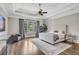 Comfortable bedroom featuring a plush bed, tray ceiling, hardwood floors, and a window at 4317 Oglethorpe Nw Loop, Acworth, GA 30101
