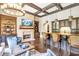 Living room with brick accent wall, fireplace, built-ins, bar area, and coffered ceiling at 4317 Oglethorpe Nw Loop, Acworth, GA 30101