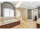 Bright bathroom features a soaking tub, a glass enclosed shower, travertine tile floors and a shuttered window at 4317 Oglethorpe Nw Loop, Acworth, GA 30101