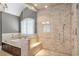 This main bathroom features a stone-tile shower, adjacent tub, and vanity mirror at 4317 Oglethorpe Nw Loop, Acworth, GA 30101