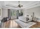 Serene bedroom features tray ceilings, a ceiling fan, hardwood floors, and a seating area with a large window at 4317 Oglethorpe Nw Loop, Acworth, GA 30101