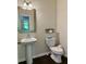 Powder room with a pedestal sink, toilet, framed mirror, and modern fixtures at 1452 Ridgebend Se Way, Mableton, GA 30126