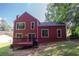 The back exterior of a red home with a wood deck at 7472 Woods Ct, Lithonia, GA 30248