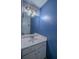 Powder room with a white sink vanity, a mirror, and a blue accent wall at 7472 Woods Ct, Lithonia, GA 30248