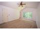 A carpeted bedroom featuring large windows and a ceiling fan at 7472 Woods Ct, Lithonia, GA 30248