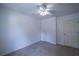 Carpeted bedroom featuring white walls and ceiling fan with access to two doors at 7472 Woods Ct, Lithonia, GA 30248