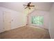 A carpeted bedroom featuring large windows and a ceiling fan at 7472 Woods Ct, Lithonia, GA 30248