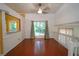 Dining room featuring hardwood floors, a ceiling fan, and natural light from a window overlooking the backyard at 7472 Woods Ct, Lithonia, GA 30248