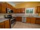 Well-lit kitchen with stainless steel appliances, wood cabinets, and granite countertops at 7472 Woods Ct, Lithonia, GA 30248