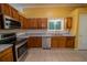 Well-lit kitchen with stainless steel appliances, wood cabinets, and granite countertops at 7472 Woods Ct, Lithonia, GA 30248