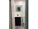 Cozy bathroom with dark vanity with white countertop and illuminated mirror above the toilet at 1120 Brandon Hill Way, Jonesboro, GA 30238