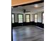 Bright living room with updated gray wood flooring, a modern ceiling fan, and multiple windows at 1120 Brandon Hill Way, Jonesboro, GA 30238