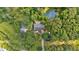 Aerial view showing home with large yard, outbuildings and tree coverage, plus a private pond at 3122 Harmony Rd, Temple, GA 30179