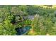 Aerial view of the property with a pond with docks and firepit, plus lush surrounding greenery at 3122 Harmony Rd, Temple, GA 30179