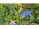 Overhead view showing pond with docks and firepit area and lush green surrounding trees at 3122 Harmony Rd, Temple, GA 30179