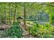 Beautiful backyard featuring a pond, bridge, and lush green landscaping at 3122 Harmony Rd, Temple, GA 30179