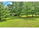 Expansive backyard with lush green grass and mature trees, ideal for outdoor activities at 3122 Harmony Rd, Temple, GA 30179