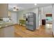 Well-lit kitchen featuring stainless steel refrigerator and view to entryway with decorative shelving and cabinets at 3122 Harmony Rd, Temple, GA 30179