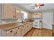 Inviting kitchen with granite countertops, natural wood cabinets, white appliances and wood flooring at 3122 Harmony Rd, Temple, GA 30179