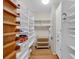 Spacious pantry with wooden and white shelving to maximize storage, adjacent to white walls and wood floor at 3122 Harmony Rd, Temple, GA 30179
