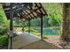 Picturesque covered dock over a tranquil pond surrounded by lush greenery at 3122 Harmony Rd, Temple, GA 30179