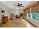 Bright sunroom features wood floors, large windows with bamboo shades, and comfortable seating area; ceiling fan present at 3122 Harmony Rd, Temple, GA 30179
