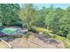 Scenic aerial view of the backyard featuring a pool, patio, firepit, and lush greenery at 4070 Runnnymede, Lilburn, GA 30047