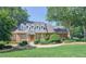 Charming brick home featuring dormer windows, mature trees and a well-manicured lawn at 4070 Runnnymede, Lilburn, GA 30047