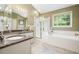 Bright bathroom featuring a double sink vanity with marble countertop and a glass-enclosed shower and tub at 4138 Glenlake Nw Ter, Kennesaw, GA 30144