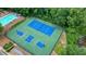 Aerial view of the community tennis and basketball courts, surrounded by a secure fence and lush trees at 4138 Glenlake Nw Ter, Kennesaw, GA 30144