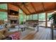 Inviting sunroom with wood plank flooring and ceiling, a stone fireplace, and comfortable seating at 4138 Glenlake Nw Ter, Kennesaw, GA 30144