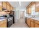 Well-lit kitchen featuring wood cabinets, appliances, and wood-look flooring at 45 Kelsey Way, Palmetto, GA 30268