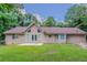 Charming home's rear exterior showing a lush, green backyard, lovely windows, and door to patio at 45 Kelsey Way, Palmetto, GA 30268