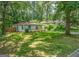 Exterior view shows a cozy one-story home with a spacious yard and mature trees for privacy at 1024 Regis Rd, Atlanta, GA 30315