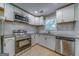 Well-lit kitchen with granite countertops, stainless steel appliances, and white cabinetry at 1024 Regis Rd, Atlanta, GA 30315