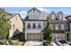 Beautiful townhome with brick and stucco exterior, two-car garage, and well-manicured landscaping at 117 Via Roma, Woodstock, GA 30188