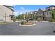 Charming townhome community featuring a landscaped roundabout and water fountain at 117 Via Roma, Woodstock, GA 30188