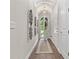 Elegant hallway featuring hardwood floors, barrel ceiling, decorative sconces, and an arched front door at 117 Via Roma, Woodstock, GA 30188
