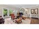 Elegant living room with hardwood floors, leather seating, and grand piano bathed in natural light at 117 Via Roma, Woodstock, GA 30188