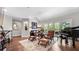 Cozy living room boasts hardwood floors, a grand piano, and ample natural light from the patio doors at 117 Via Roma, Woodstock, GA 30188